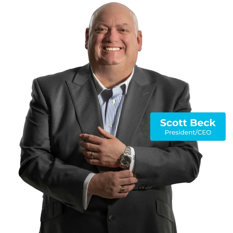 Smiling bald man in gray suit adjusting his watch against a white background with CEO name tag.