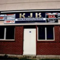 Brick building entrance with white door and K.J.K private detectives signage above the door