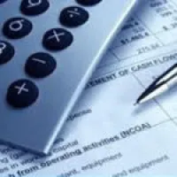 Calculator and pen on financial document showing numbers and text about income and expenses.